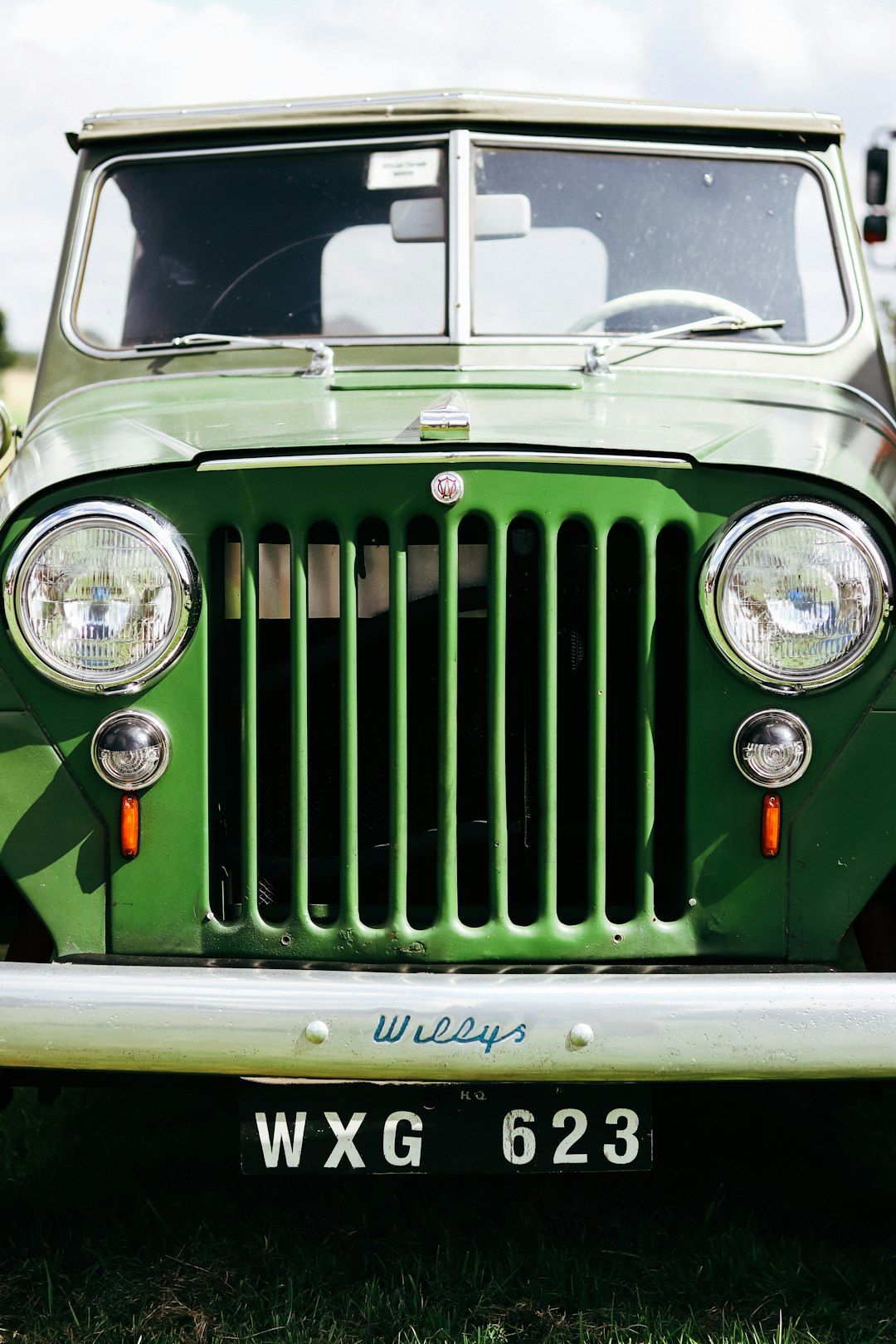 a green jeep is parked in the grass