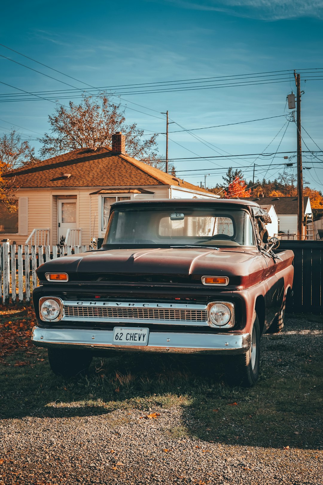 an old truck parked in a yard next to a house