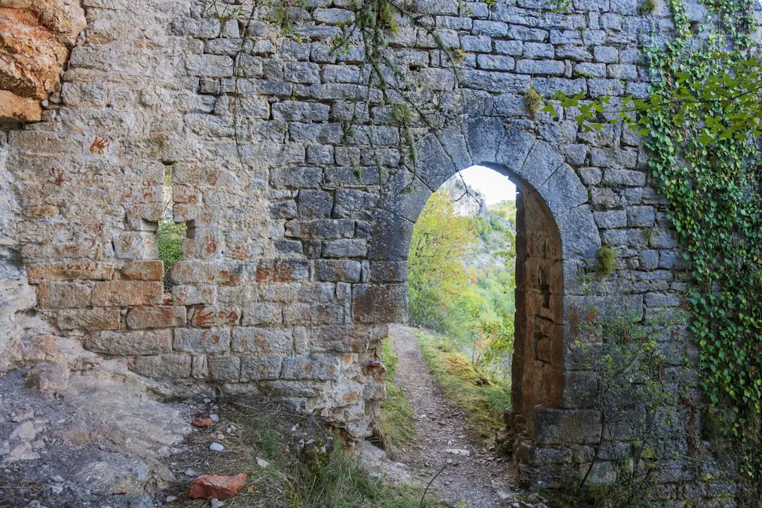 a stone wall with an arched doorway in it