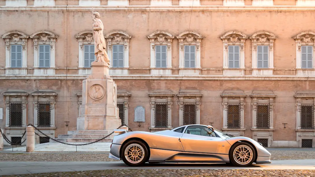 A silver sports car parked in front of a building